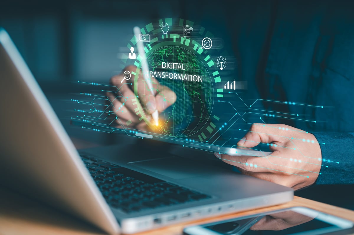 Person interacting with tablet and laptop featuring digital transformation concept